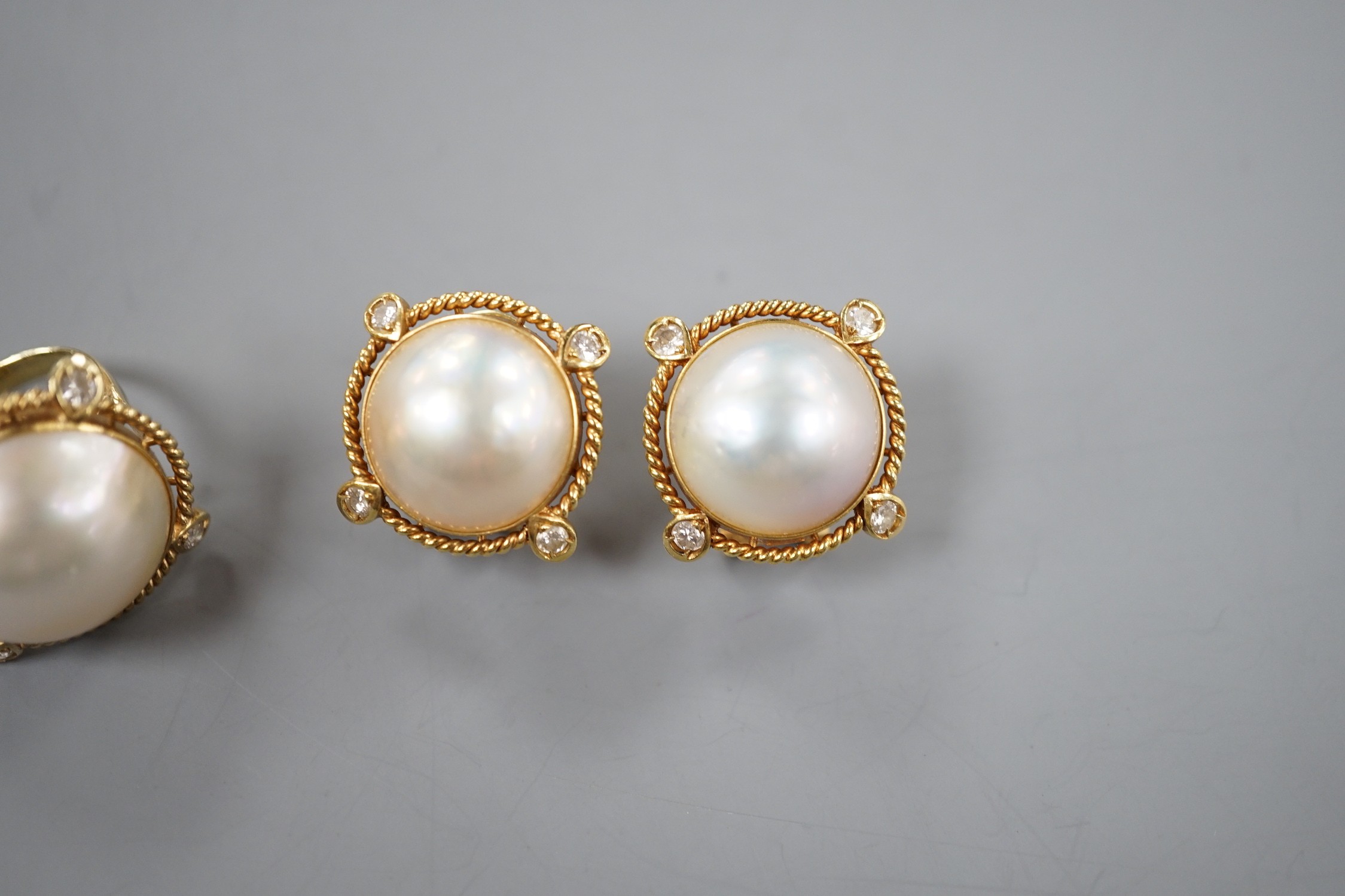 A yellow metal, mabe pearl and four stone diamond chip set dress ring, size H and a pair of similar earrings stamped 585 14k, gross weight 17.1 grams.